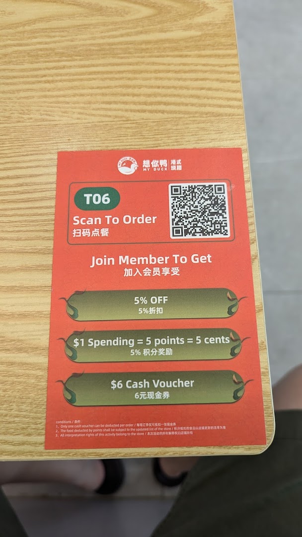 A table card from M.Y Duck displaying a QR code for ordering and member benefits.