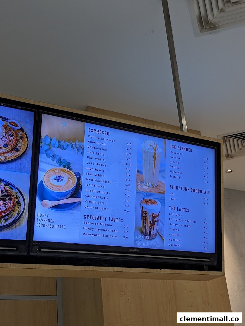 A digital menu board displaying a variety of coffee, blended drinks, and tea lattes.