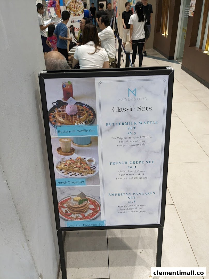 A menu board for MADLYGOOD showcasing classic waffle, crepe, and pancake sets with prices.