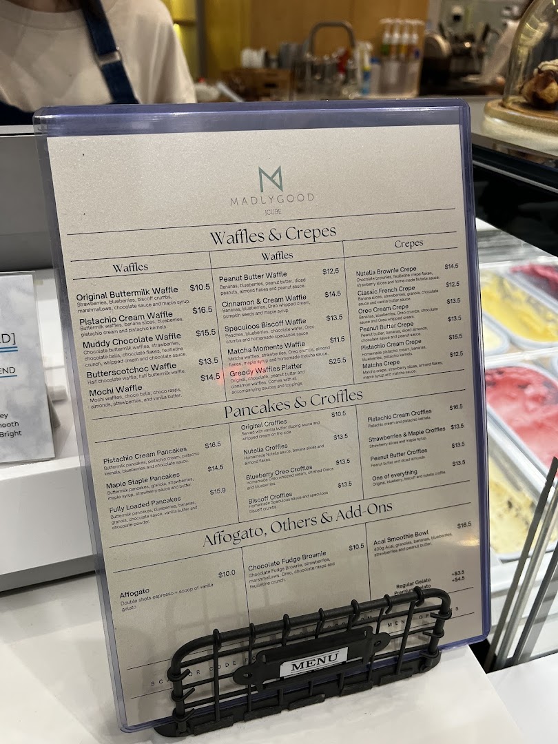A detailed menu board for MADLYGOOD, featuring waffles, crepes, pancakes, and desserts.