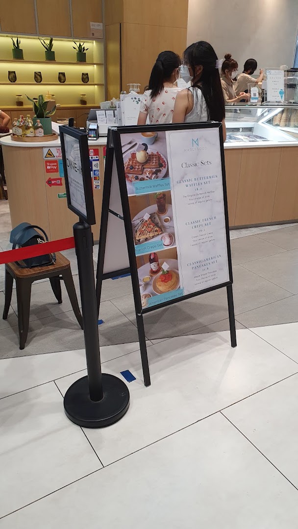 An A-frame sign displaying classic dessert sets and prices for MADLYGOOD.