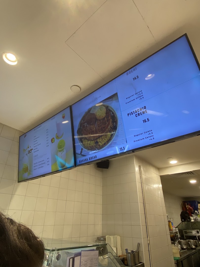 Digital menu boards display desserts, drinks, and prices inside MADLYGOOD.