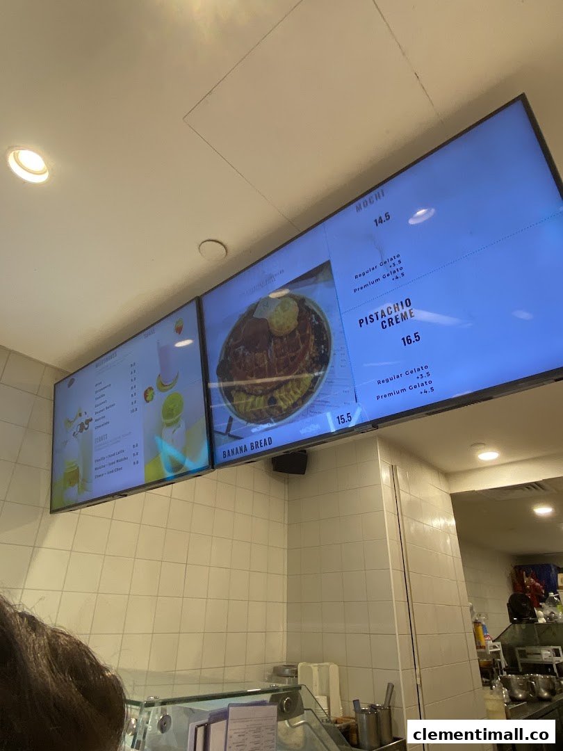 Digital menu boards display desserts, drinks, and prices inside MADLYGOOD.
