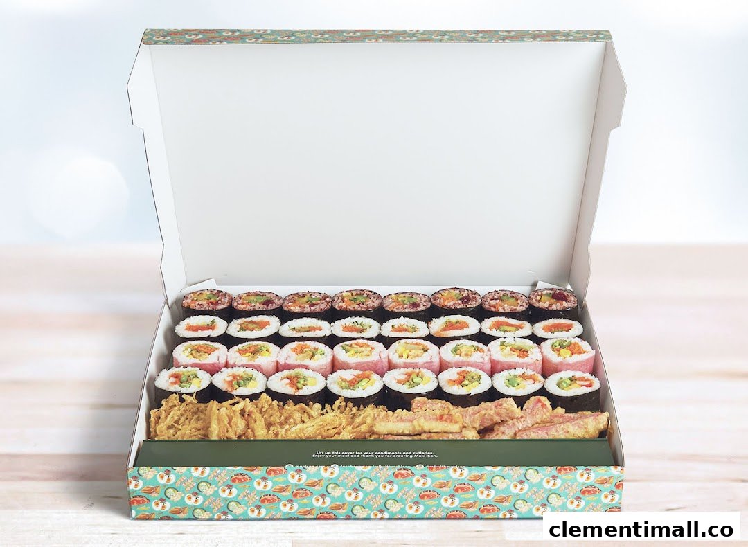 An open Maki-San box filled with assorted sushi rolls and fried tempura items.
