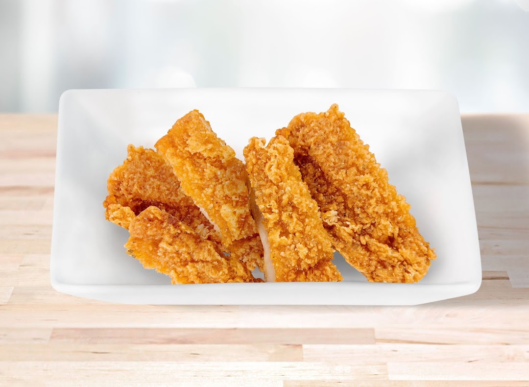 A white rectangular dish filled with golden-brown crispy fried food pieces on a wooden surface.