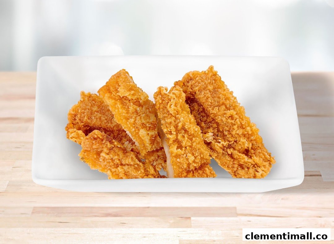 A white rectangular dish filled with golden-brown crispy fried food pieces on a wooden surface.