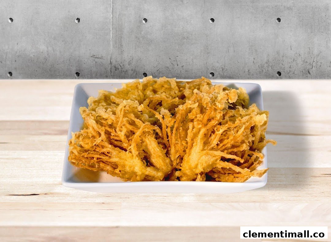 A plate of crispy golden-brown tempura-style enoki mushrooms on a white dish.