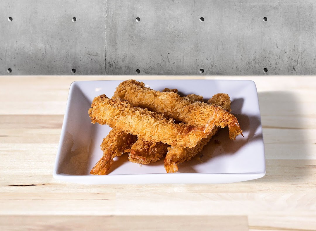 Crispy breaded fried shrimp served on a white rectangular plate.