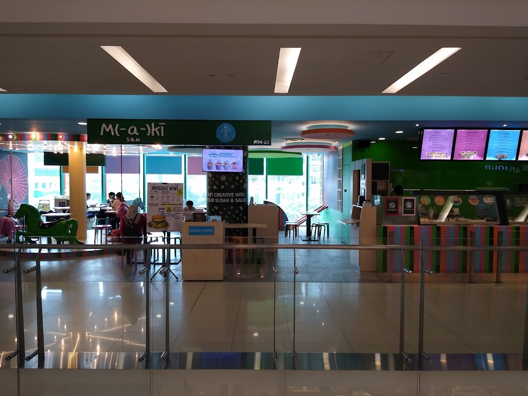 A vibrant interior view of Maki-San, showing customers dining and the colorful counter area.