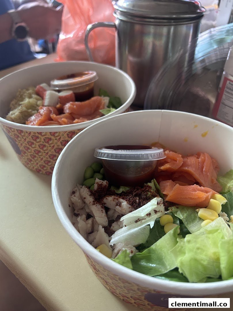 Two colorful food bowls, likely poke or salad, with salmon, vegetables, and sauce.