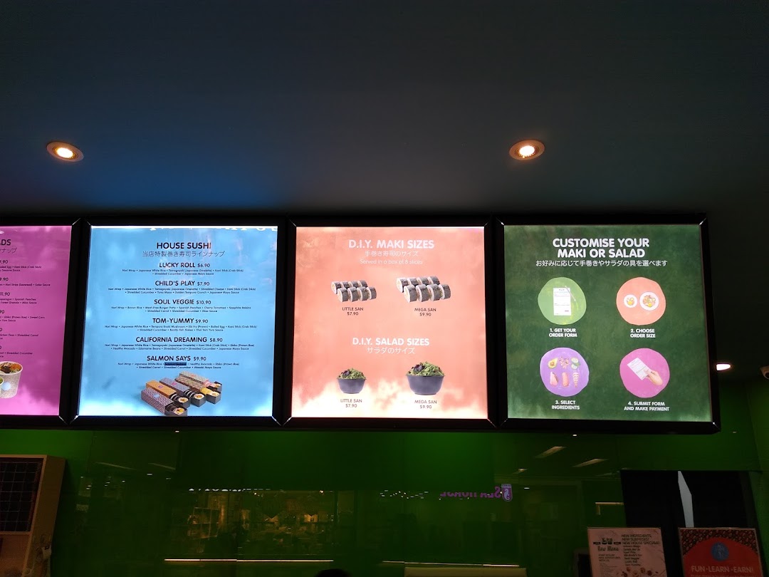 Brightly lit menu boards display Maki-San's customisable sushi and salad options with prices.