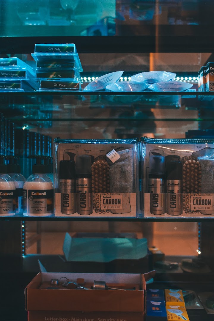 Close-up of shelves displaying various shoe care products and accessories, including gels and cleaning kits.