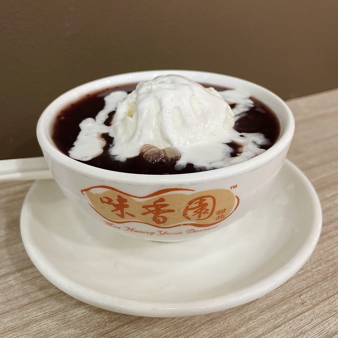 A delicious bowl of red bean dessert topped with a generous scoop of vanilla ice cream.