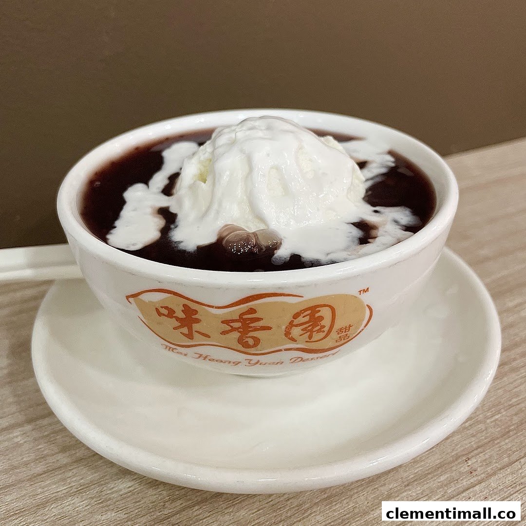 A delicious bowl of red bean dessert topped with a generous scoop of vanilla ice cream.