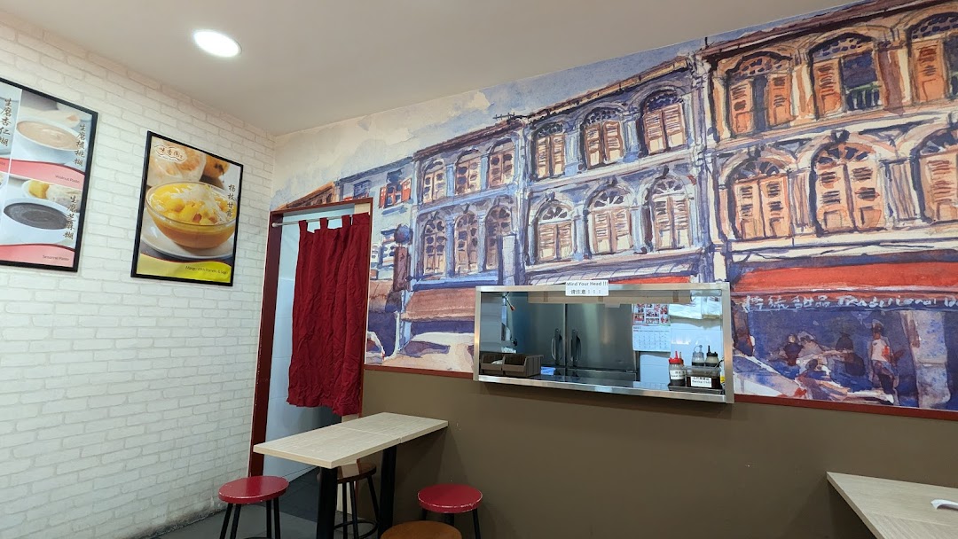 Interior view of Mei Heong Yuen Dessert, featuring a vibrant mural, cozy seating, and dessert posters.
