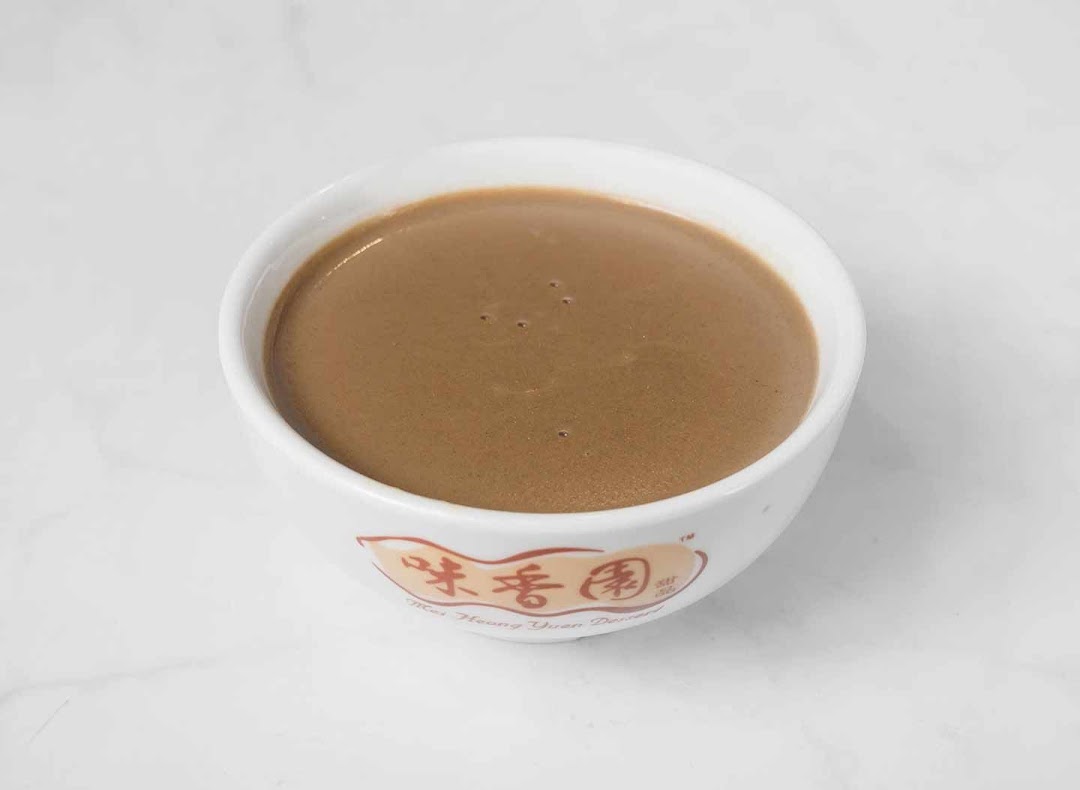 A close-up of a bowl of traditional brown dessert, likely sesame or peanut paste, from Mei Heong Yuen.