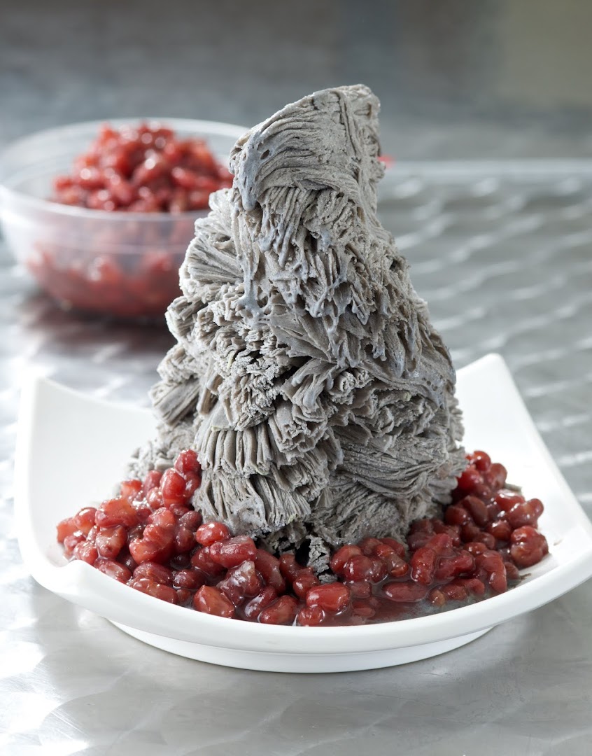 A towering black sesame shaved ice dessert served with sweet red beans.