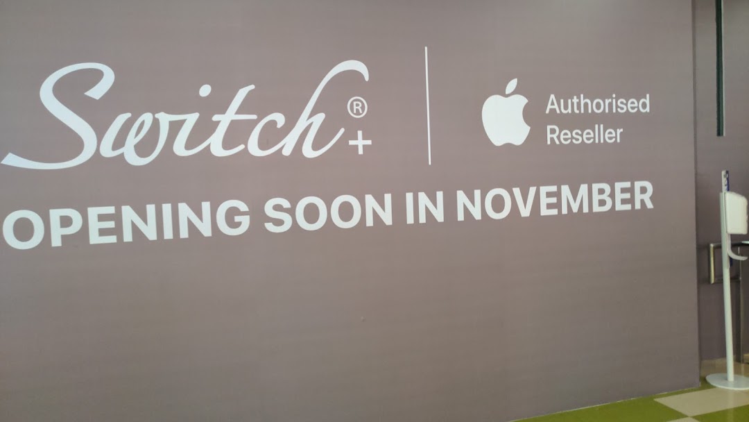 A large wall sign for Switch+, an Apple Authorised Reseller, announcing its opening soon in November.