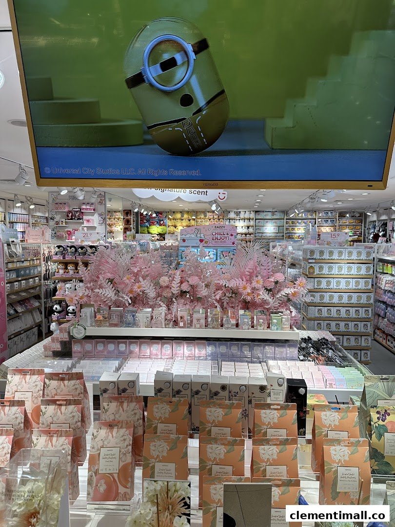 Vibrant interior of MINISO, showcasing diverse lifestyle products, a large screen, and a decorative pink floral display.