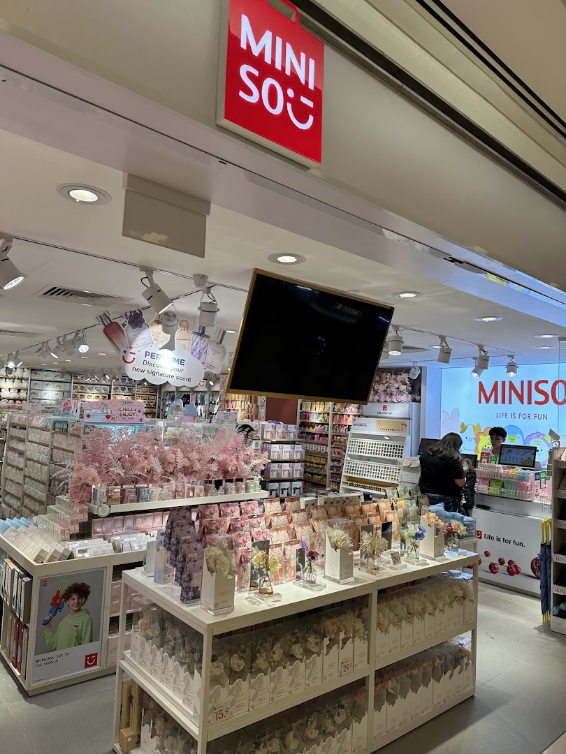 Interior view of MINISO store showcasing diverse products, displays, and checkout area.