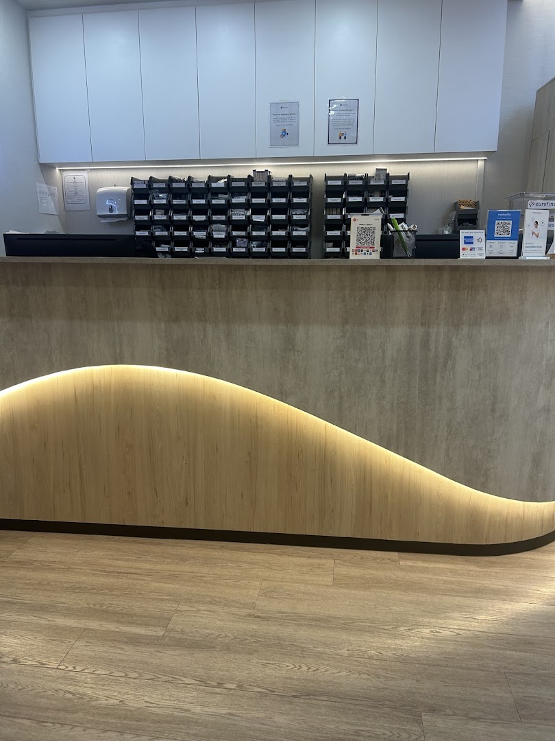 A clean and modern reception desk area inside Minmed Clinic Clementi, featuring a wave-patterned counter.
