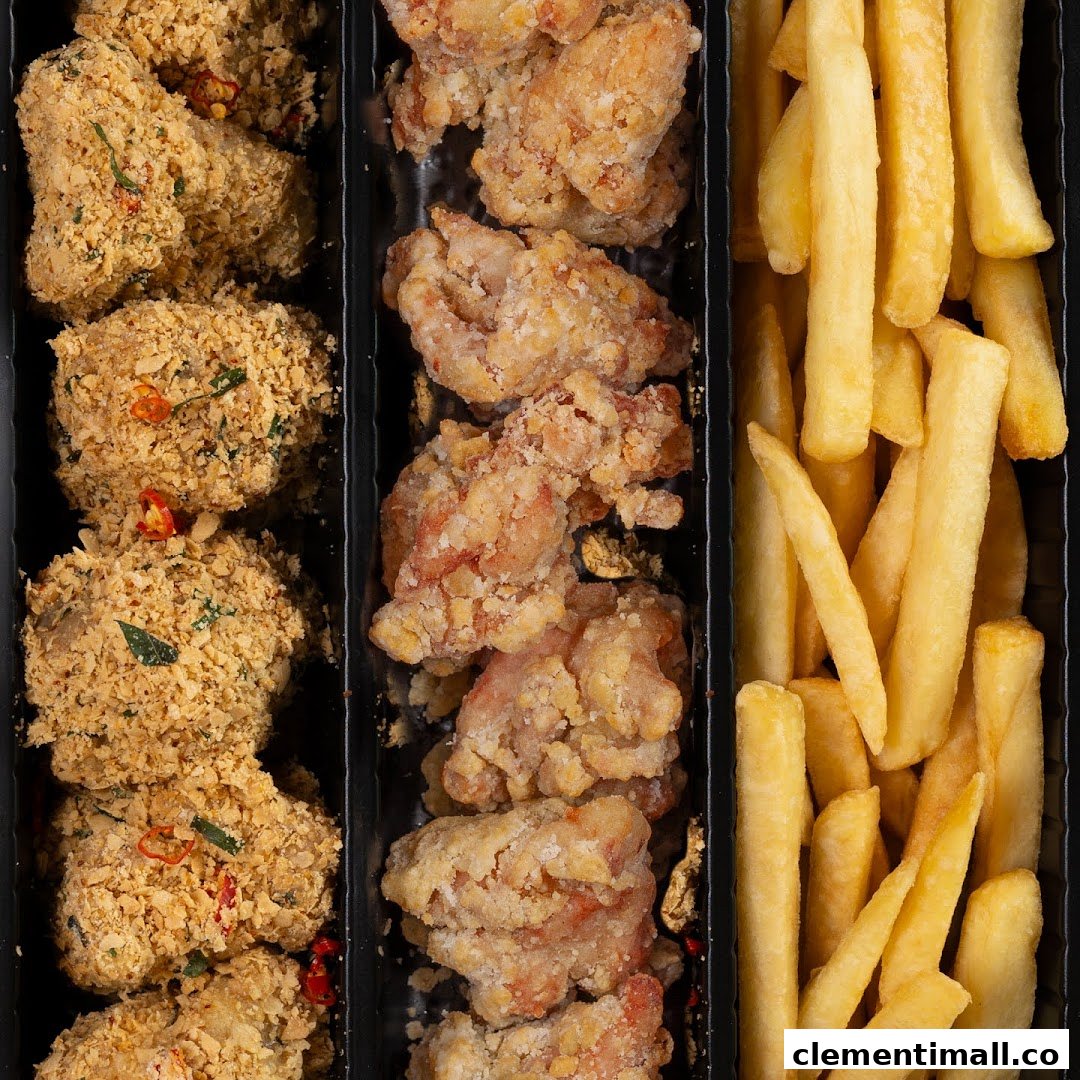 Close-up of a food container featuring crispy fried chicken pieces, some with a spiced coating, and golden french fries.