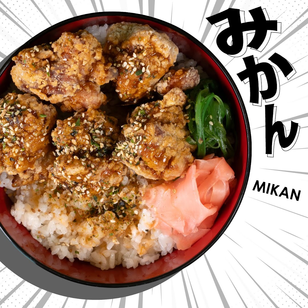 A vibrant bowl of crispy fried chicken with rice, seaweed, and pickled ginger.
