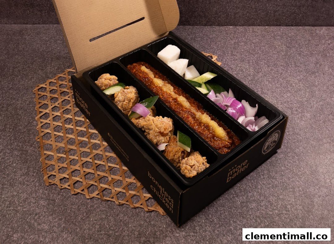 A takeaway box from More Batter featuring boneless fried chicken, sambal, and fresh vegetables.