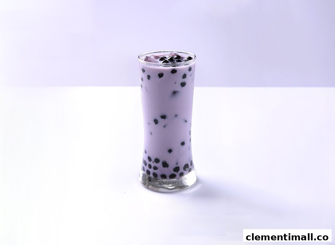 A tall glass of purple bubble tea with dark boba pearls on a white background.