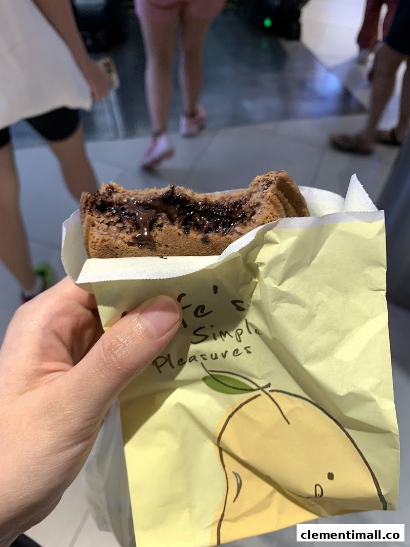 A hand holds a partially eaten chocolate-filled waffle from Mr Bean in a yellow wrapper.