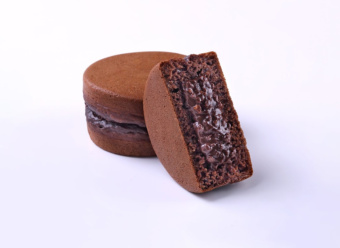 A chocolate pancake with rich chocolate filling, one whole and one cut to show the interior.