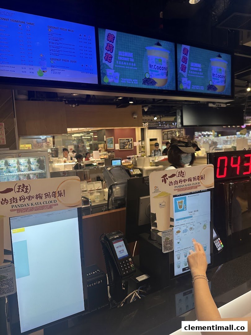 Digital menu boards and self-service kiosk at Mr Coconut, showcasing various coconut beverages.