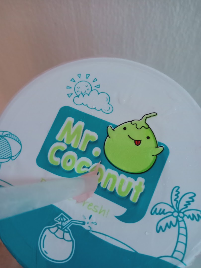 Close-up of a Mr Coconut drink cup lid featuring its logo and a straw.