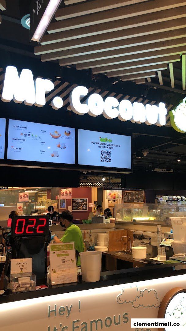 An interior shot of Mr Coconut, featuring the service counter, staff, and digital menu displays.