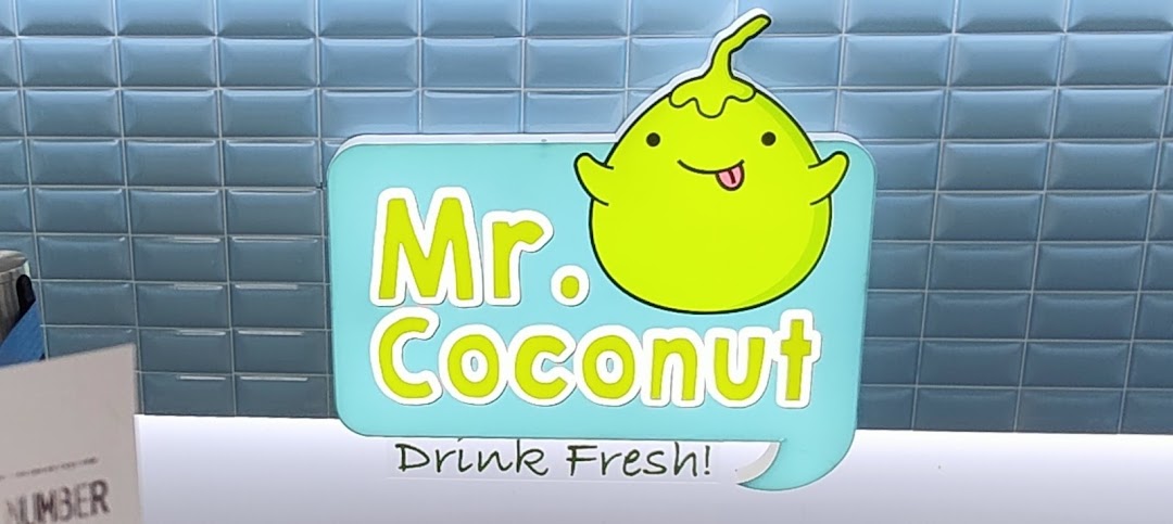 Close-up of the vibrant Mr Coconut shop logo featuring a cheerful coconut character and tagline.