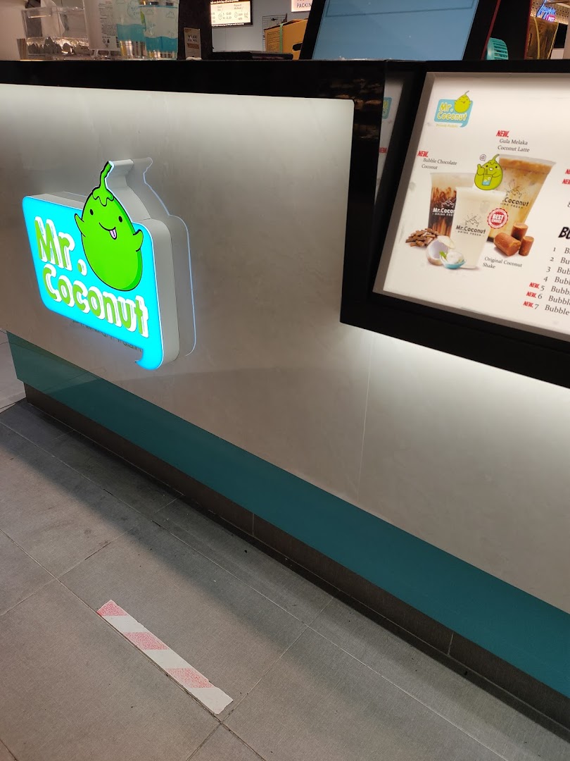 A close-up of the Mr Coconut counter featuring its vibrant logo and a display board with new drink offerings.