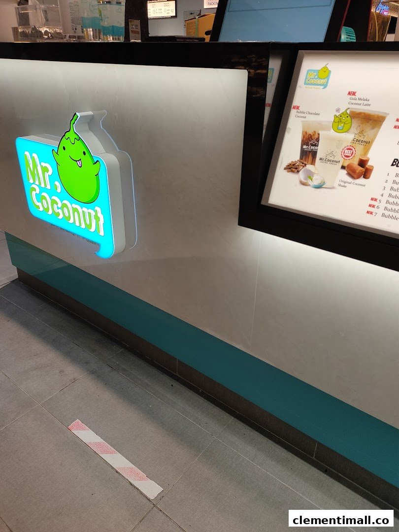A close-up of the Mr Coconut counter featuring its vibrant logo and a display board with new drink offerings.