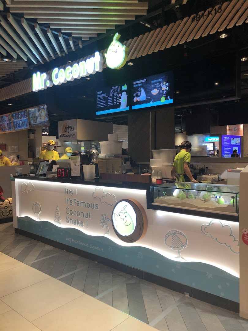 A vibrant Mr Coconut shop counter with staff, featuring its signature coconut shakes and desserts.