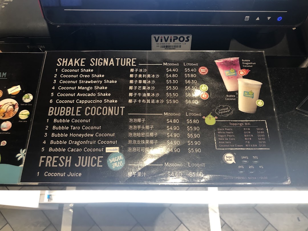 A detailed menu board displaying various coconut shakes, bubble coconut drinks, fresh juice, and toppings.