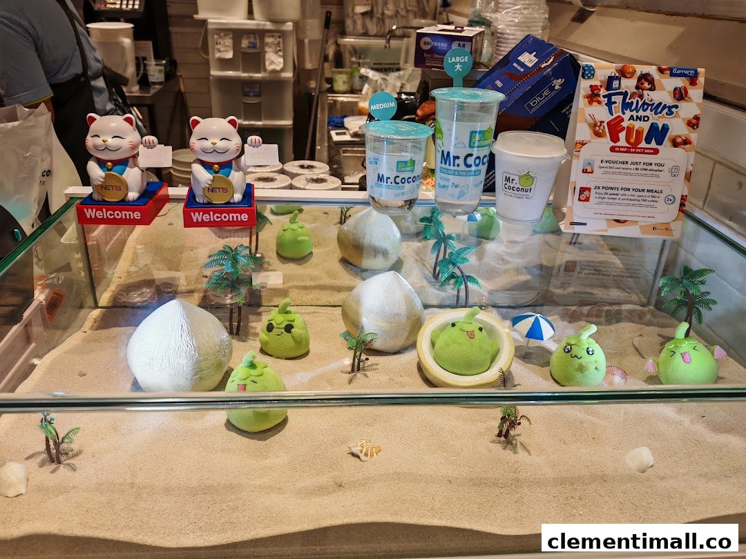 A vibrant display case at Mr Coconut featuring sand, decorative coconuts, and brand merchandise.