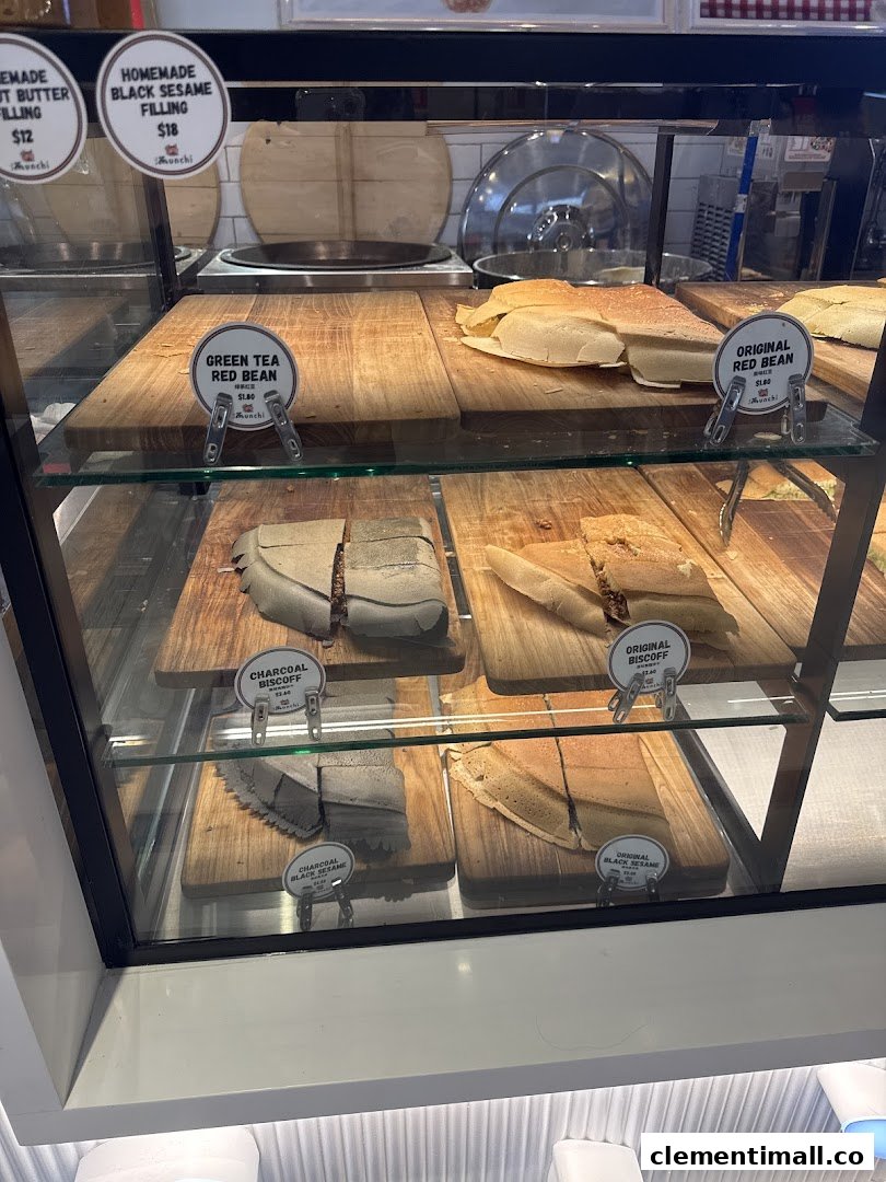 A display case at Munchi Pancakes showcasing various pancake flavors and fillings with prices.