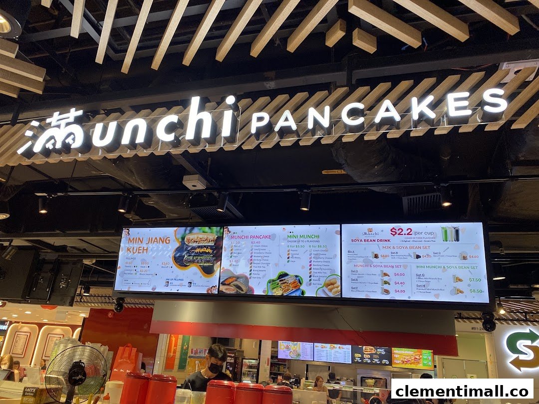 A digital menu board displaying various pancake and soya bean drink options at Munchi Pancakes.