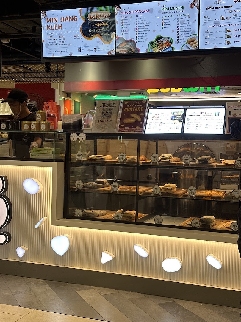 A vibrant view of Munchi Pancakes' counter, showcasing their pancake display and detailed menu boards.