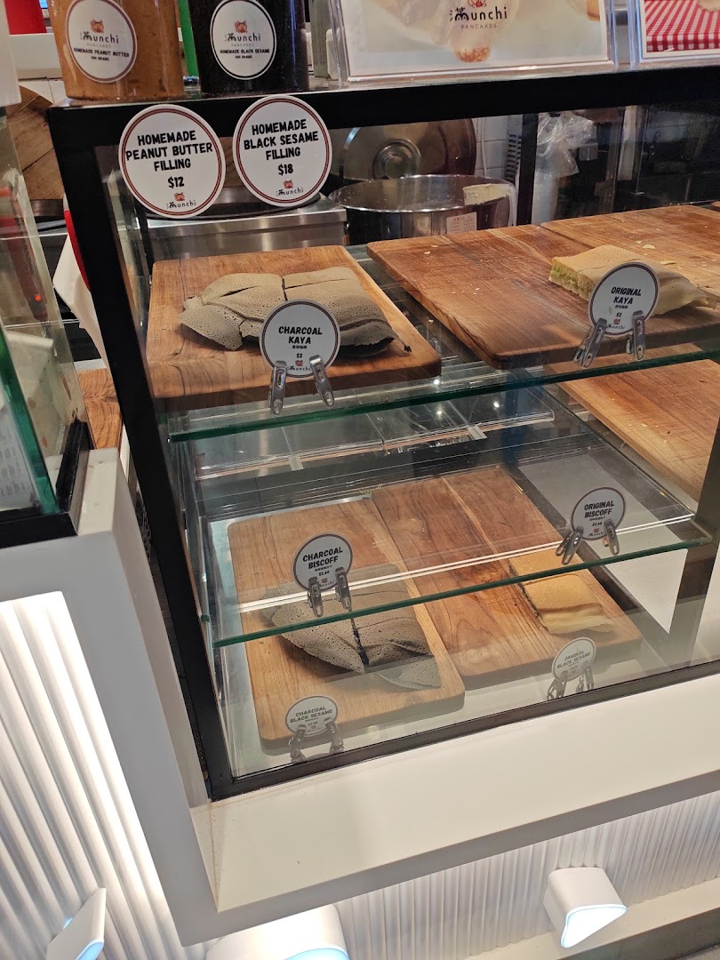 A display case showcasing various Munchi Pancakes fillings and flavors like Charcoal Kaya and Homemade Peanut Butter.
