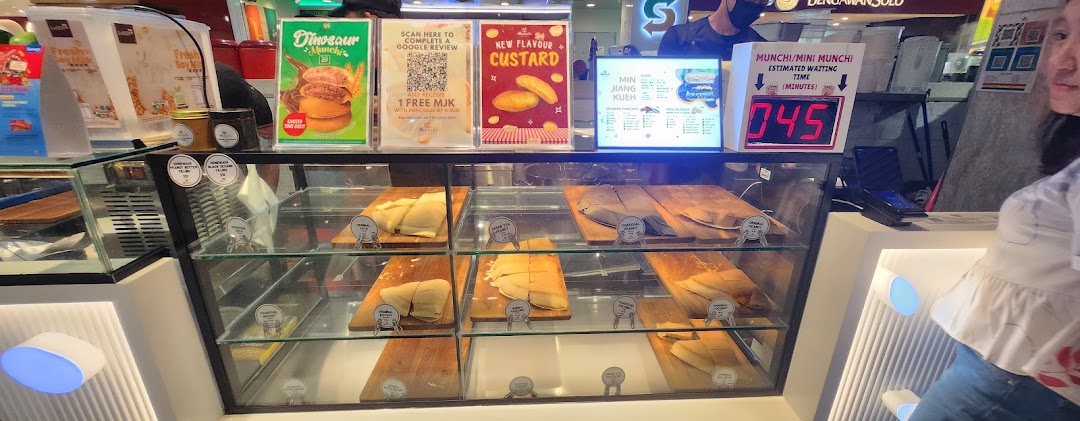 A vibrant counter at Munchi Pancakes showcasing various pancake flavors and promotional displays.
