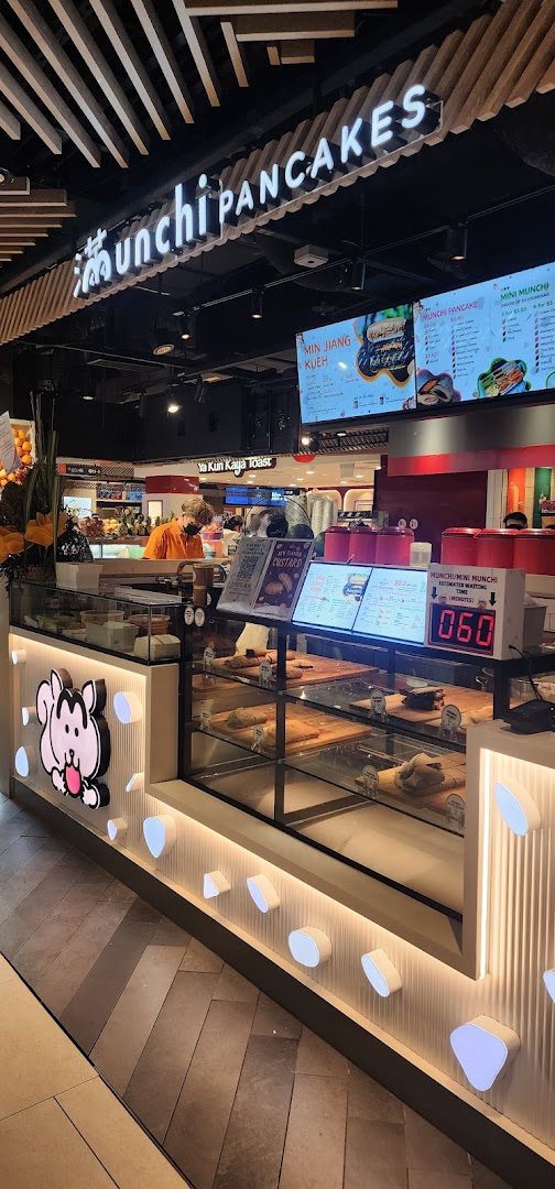 A vibrant counter at Munchi Pancakes showcasing their delicious pancake offerings and menu boards.