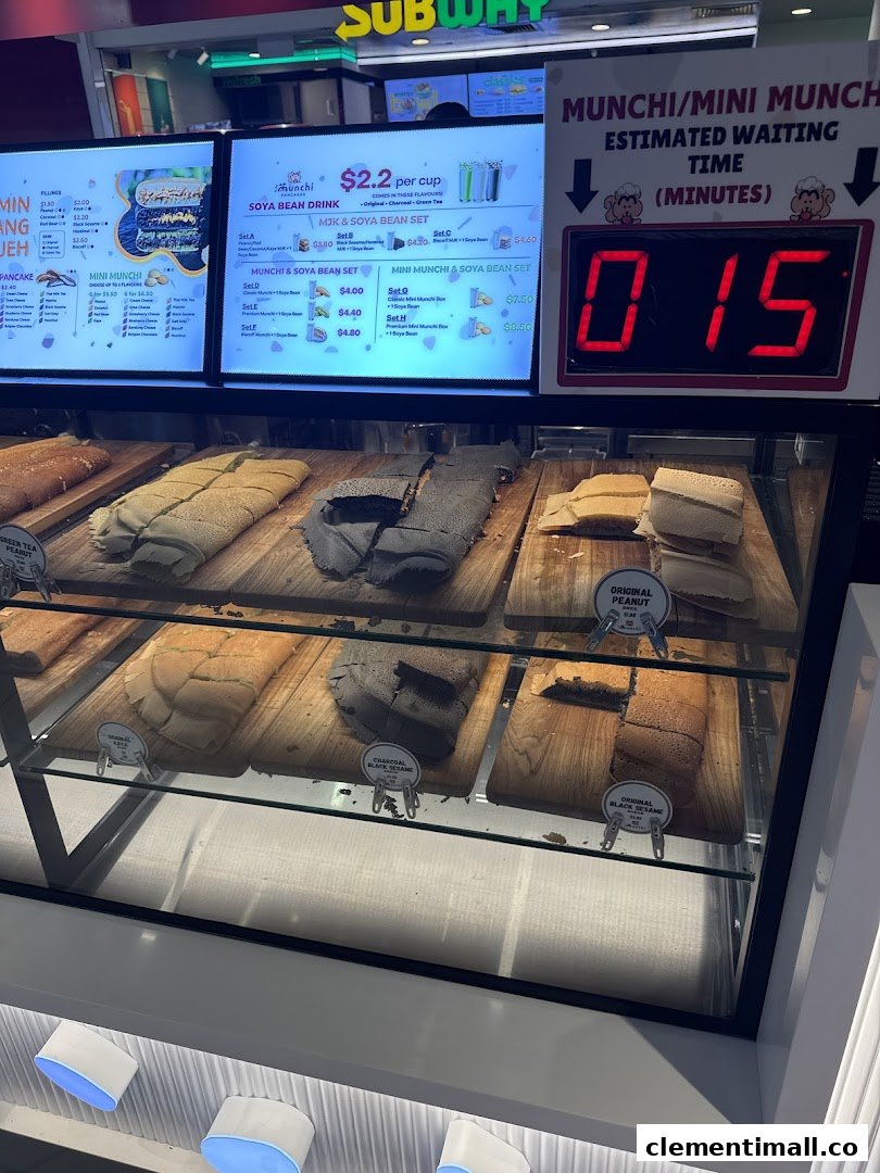 A display case showcasing various Munchi pancakes with digital menu boards and a waiting time display.