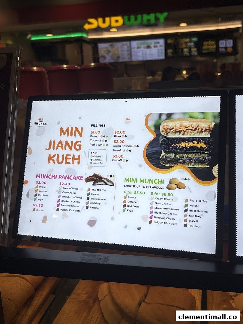 A digital menu board for Munchi Pancakes, displaying various pancake types, fillings, and prices.