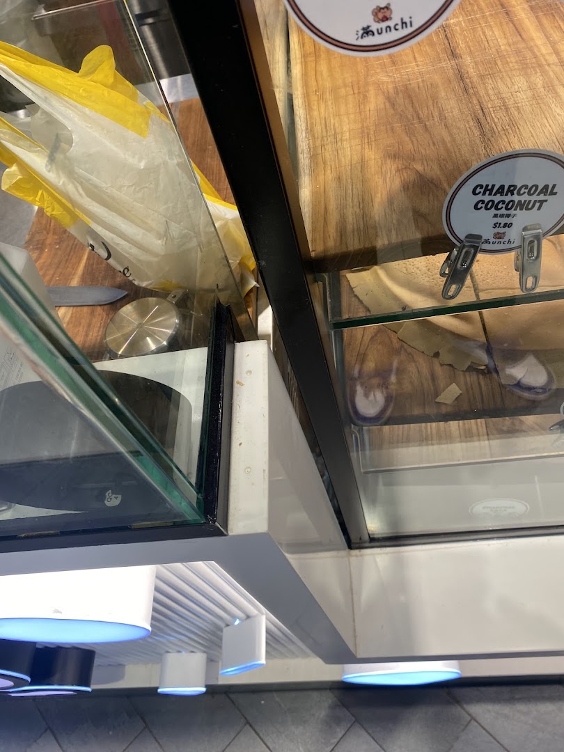 A close-up view of a retail display case at Munchi Pancakes, featuring a Charcoal Coconut product label.