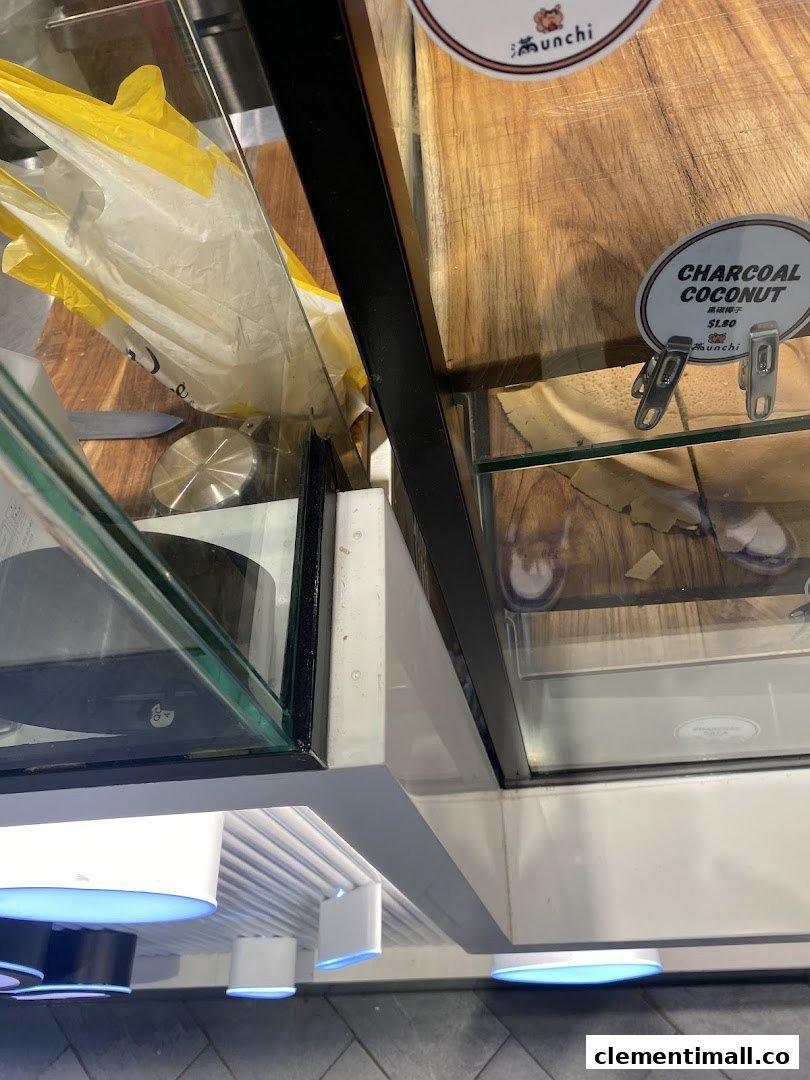 A close-up view of a retail display case at Munchi Pancakes, featuring a Charcoal Coconut product label.